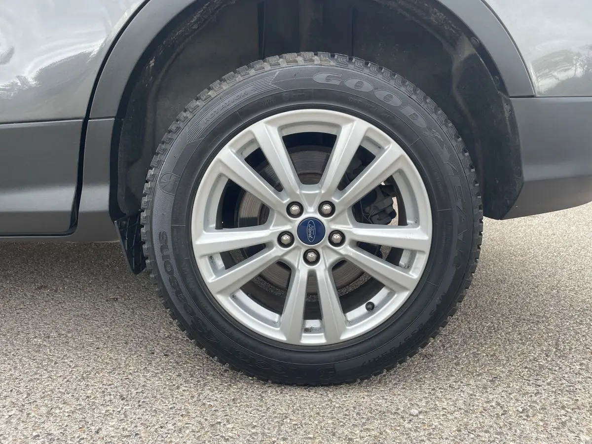 Gros plan sur la roue avant droite du Ford Kuga gris 2017, avec jante alliage et pneu Goodyear.