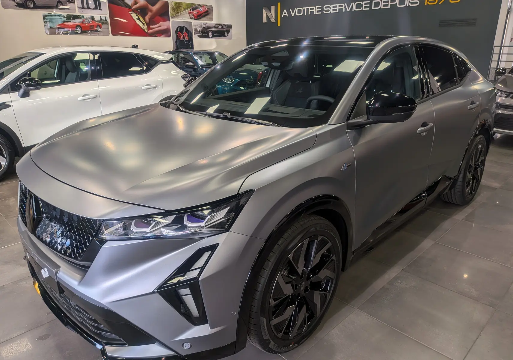 Renault Rafale E-Tech gris Schiste Satin en 3/4 avant droit, avec jantes noires et détails noirs brillants.