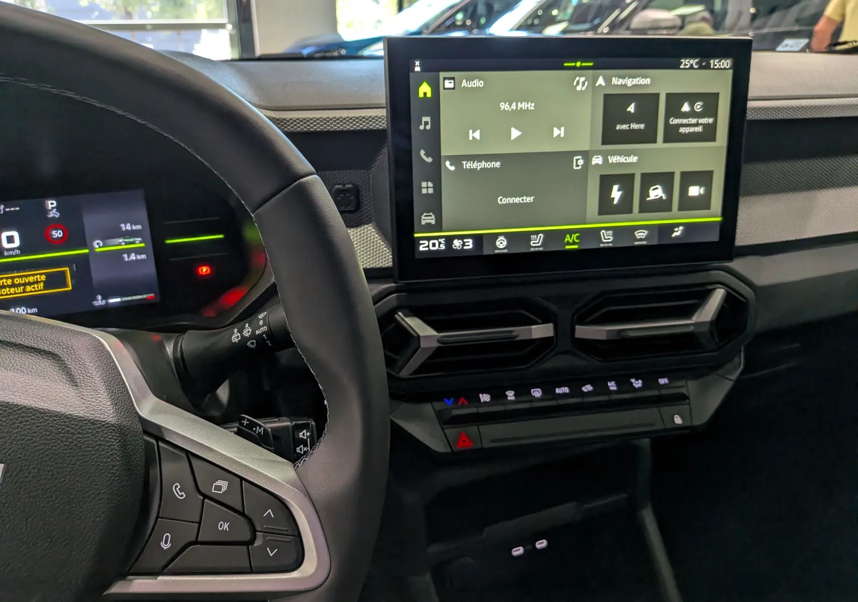 Vue intérieure du tableau de bord du Dacia Duster Hybrid-G 150 CH 4x4, avec écran tactile central et volant partiel visible.