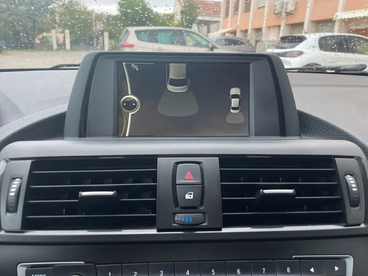 Vue rapprochée de l'écran central et des commandes de ventilation d'une BMW Série 2 Coupé F22 blanche de 2014.