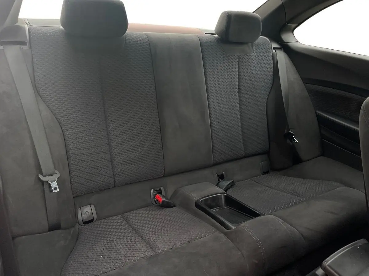 Banquette arrière en tissu noir de la BMW Série 2 Coupé F22 220d M Sport, avec accoudoir central et ceintures visibles.