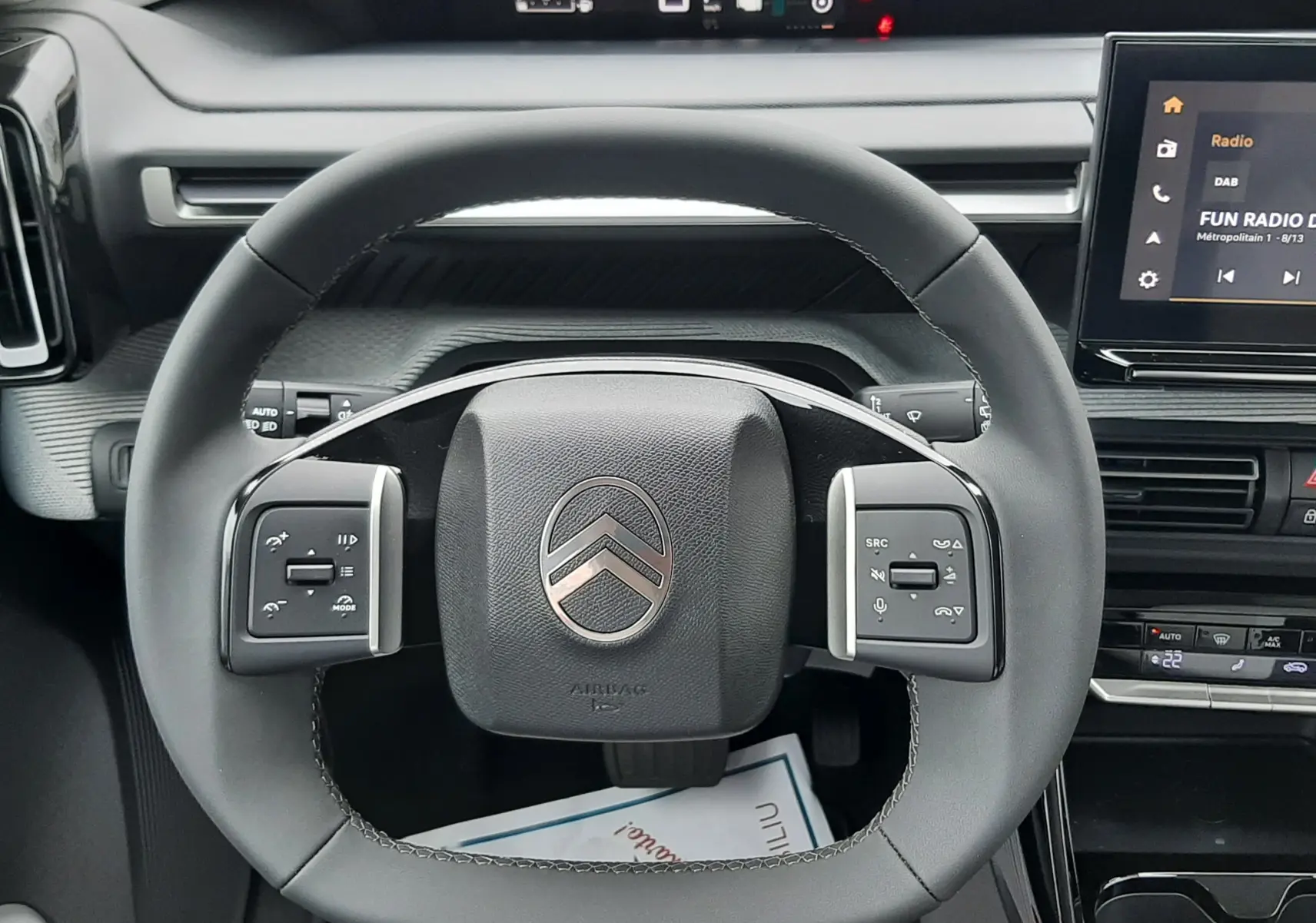 Vue centrée sur le volant noir du Citroën C3 Aircross 2026 gris Mercury, avec tableau de bord digital et écran tactile visible.