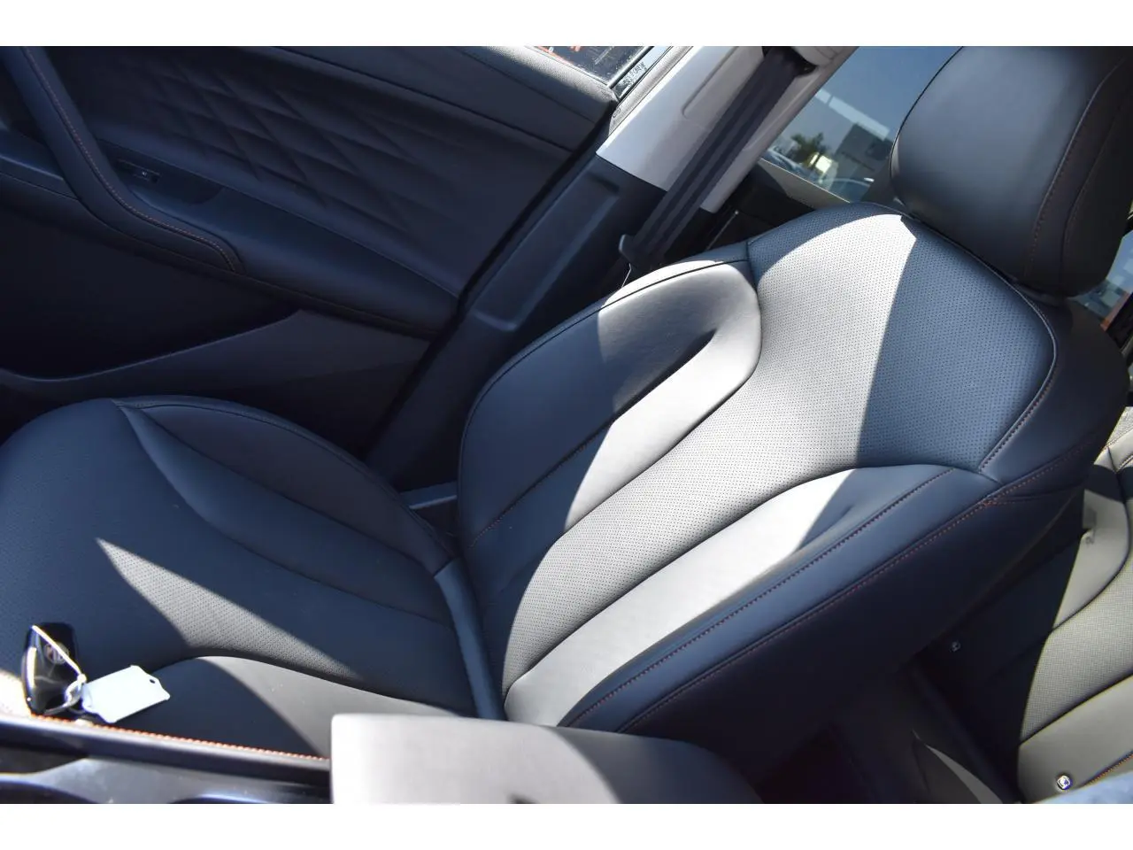 Gros plan sur le siège conducteur en similicuir noir avec surpiqûres marron du MG Motor EHS 1.5 Hybrid+ Luxury 2026.