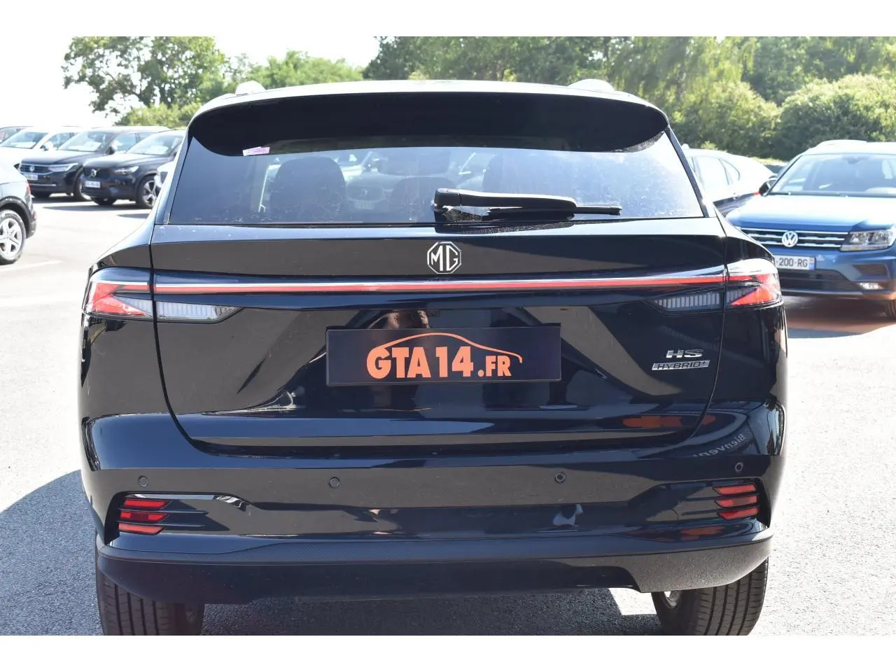 Vue arrière d'un MG MOTOR EHS 1.5 Hybrid+ noir avec feux LED et logo MG visible en plein jour.