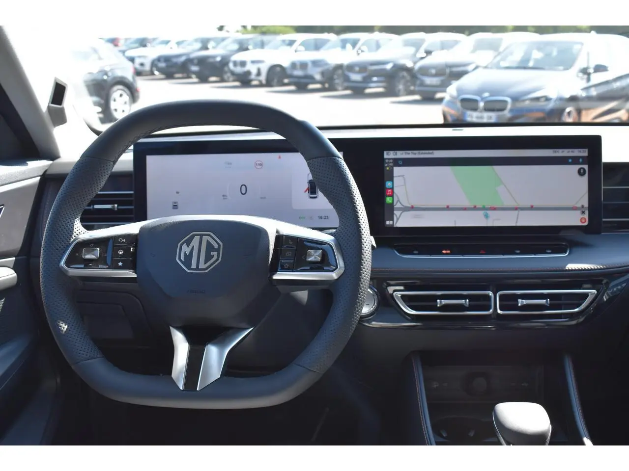Vue intérieure centrée sur le volant noir MG et le tableau de bord numérique avec écran tactile large affichant la navigation.