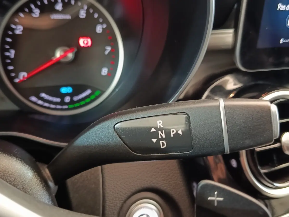 Gros plan sur la commande de boîte automatique noire dans l’habitacle d’un Mercedes GLC 300 DE bleu, tableau de bord partiellement visible.