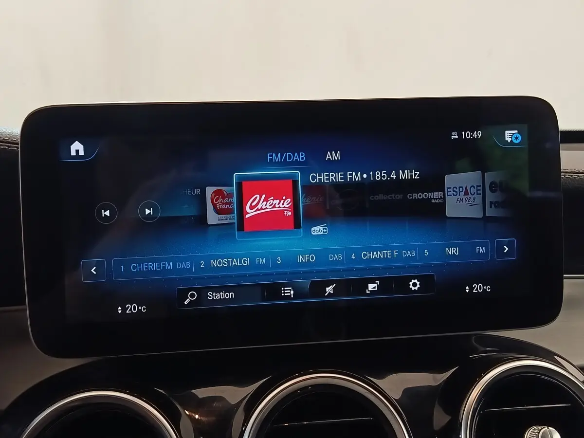 Écran tactile central affichant la radio FM dans l’habitacle d’un Mercedes GLC bleu, vue de face rapprochée.