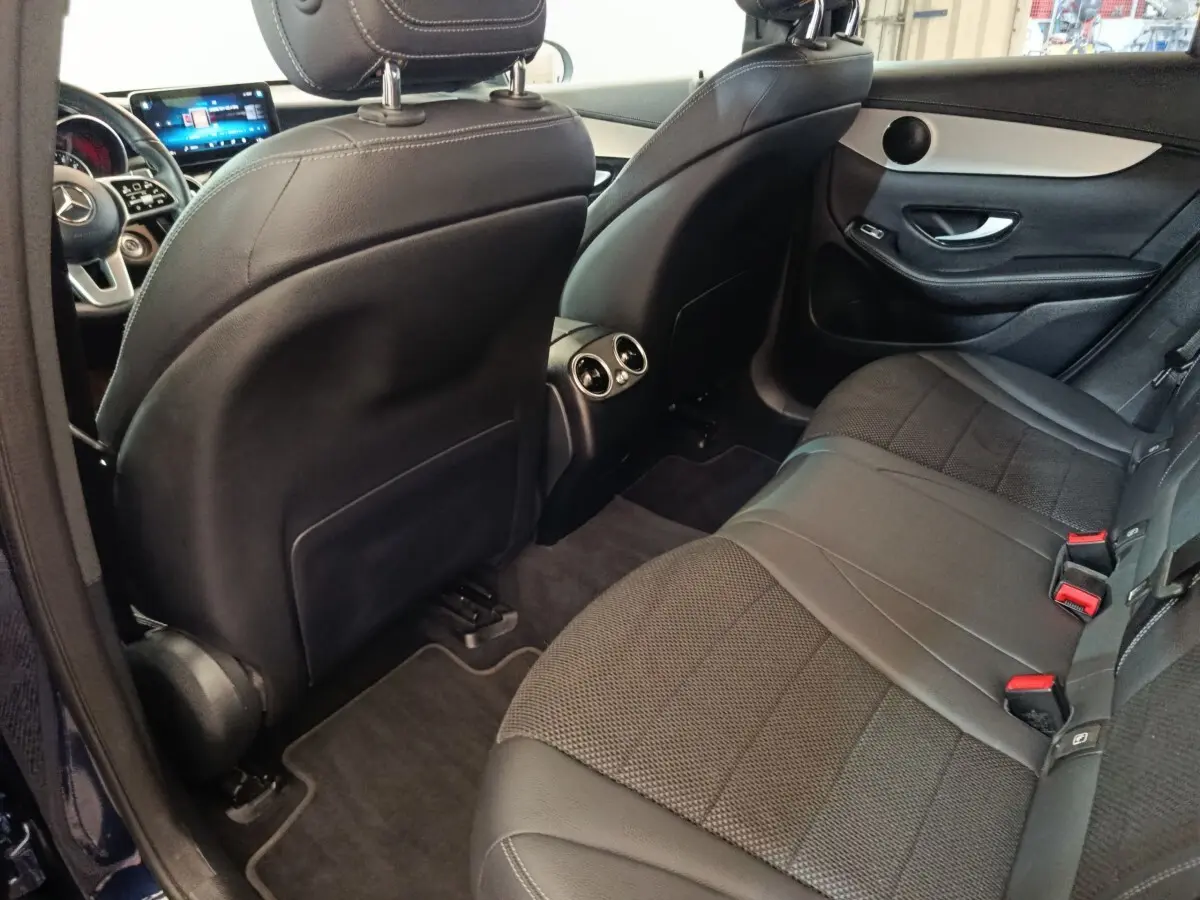 Vue intérieure arrière côté droit du Mercedes GLC 300 DE Business Line 2022, sièges noirs en cuir et tissu, aérateurs centraux visibles.
