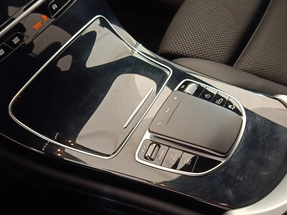 Gros plan sur la console centrale noire brillante du Mercedes GLC 300 DE Business Line 2022, avec pavé tactile et commandes.