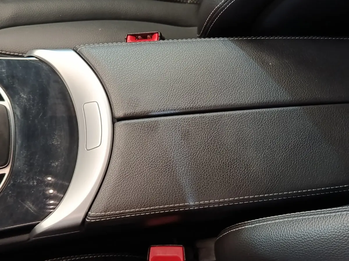 Détail de l'accoudoir central en cuir noir avec coutures blanches dans l'habitacle d'une Mercedes GLC 300 hybride rechargeable.