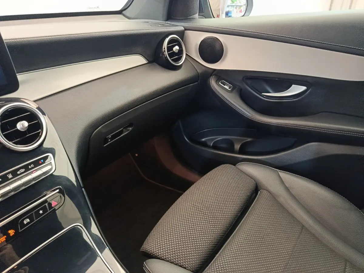 Vue intérieure côté passager avant du Mercedes GLC 300 DE Business Line 2022, avec tableau de bord noir et détails argentés.