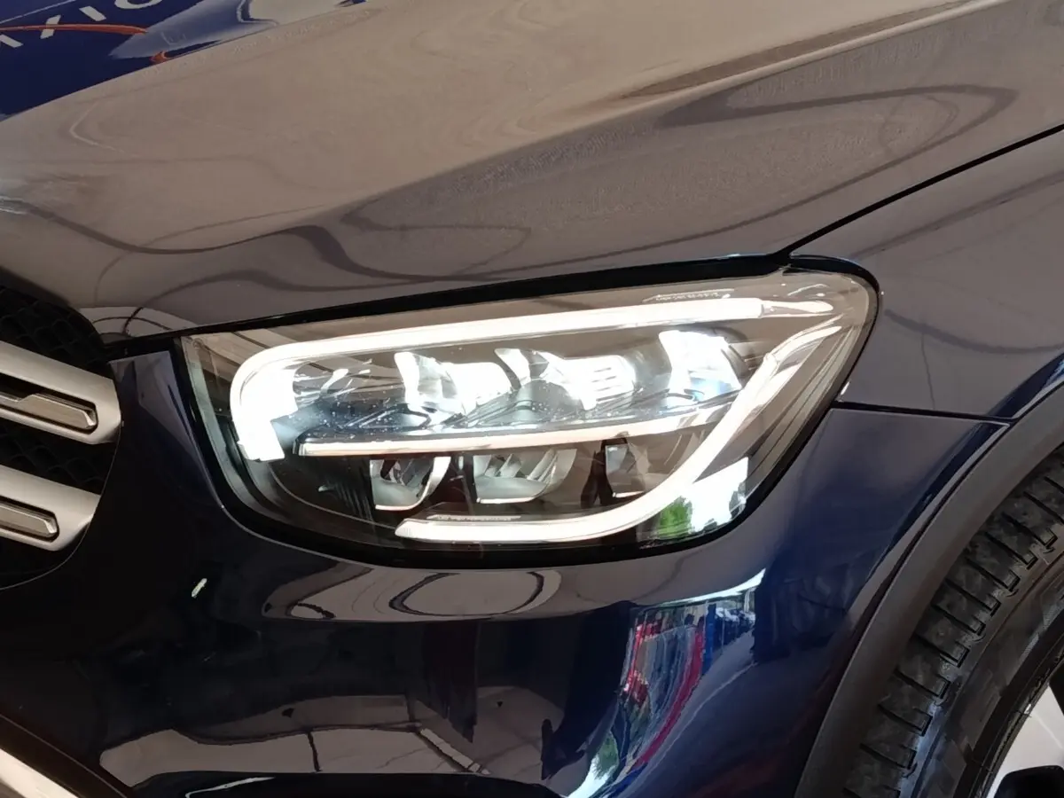 Gros plan sur le phare avant droit LED d’un Mercedes GLC 300 DE Business Line bleu 2022.