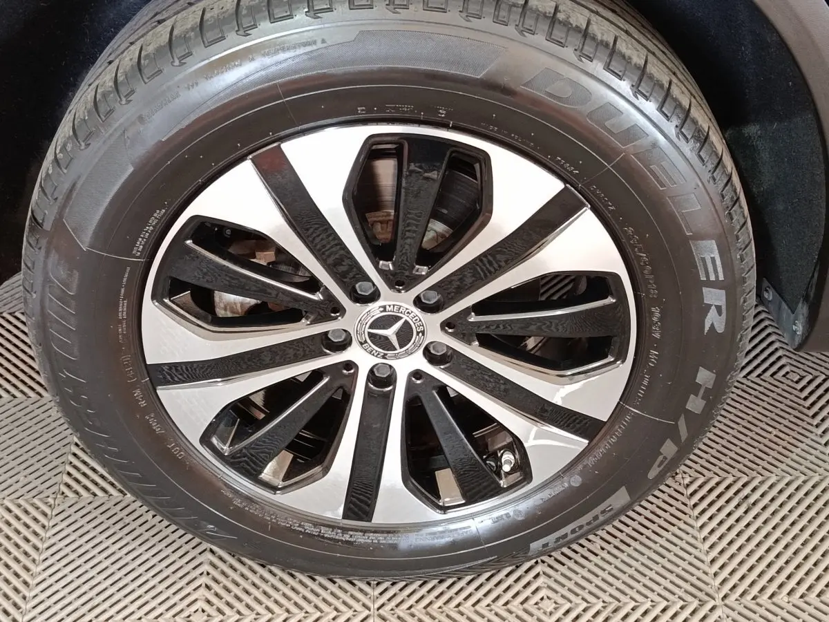 Gros plan sur la jante alliage bicolore noire et argent avec logo Mercedes au centre, pneu Bridgestone visible.