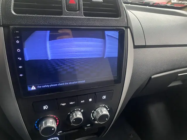 Vue rapprochée de l'écran tactile central et des commandes de climatisation du tableau de bord gris et noir du DFSK EC35 blanc électrique.