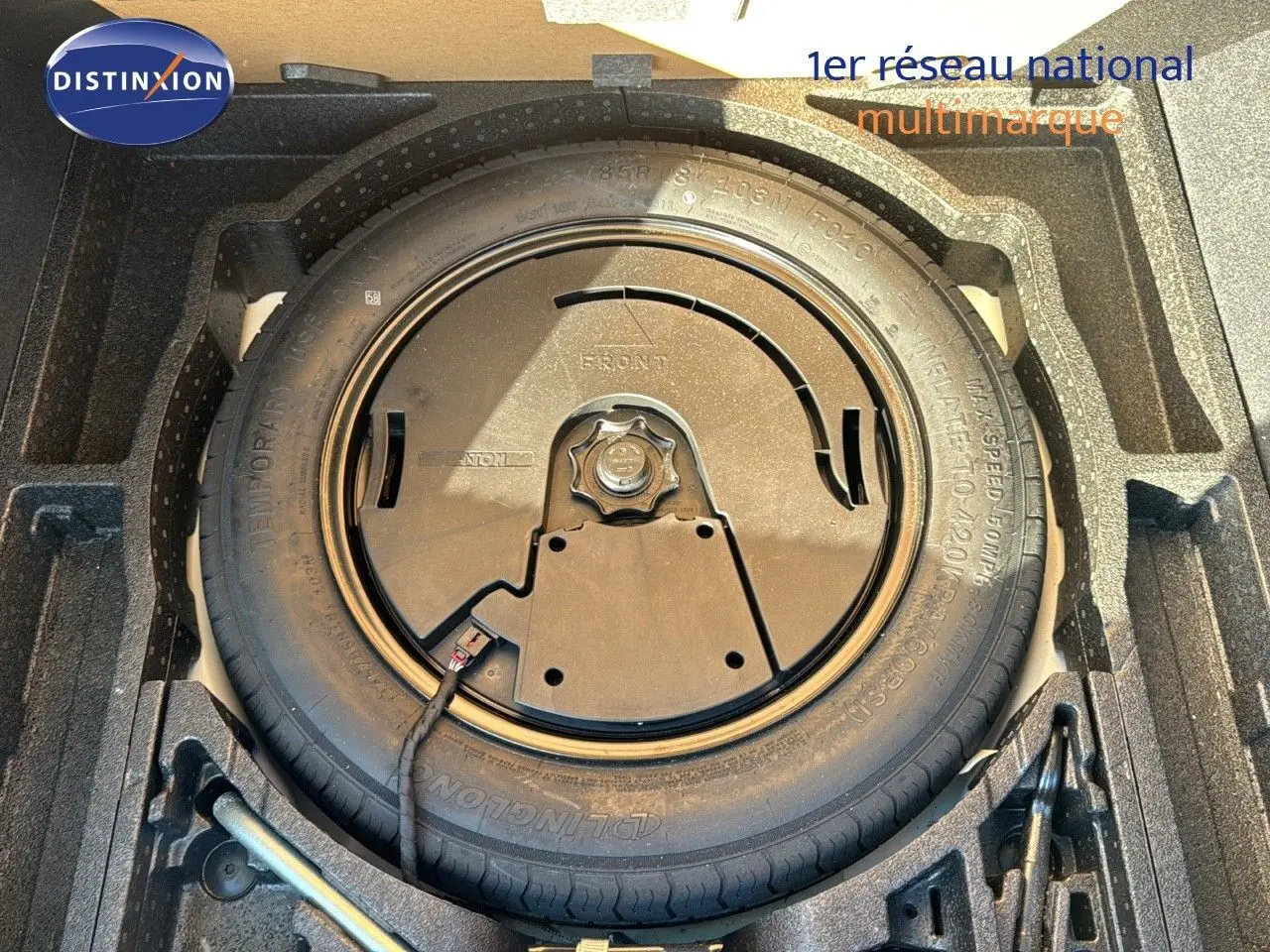 Gros plan sur la roue de secours dans le coffre d'un Skoda Kodiaq blanc 2018, avec rangement en mousse noire.