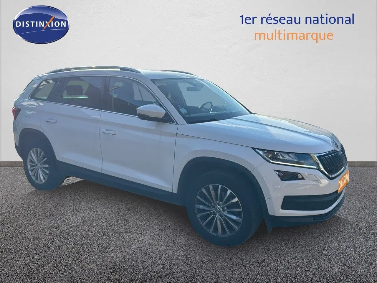 Vue 3/4 avant droite d'un Skoda Kodiaq blanc 2018 avec jantes alliage et calandre noire distinctive.