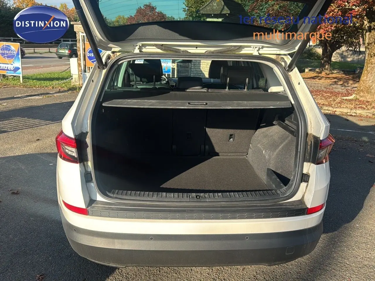 Vue arrière d'un SKODA KODIAQ blanc de 2018 avec coffre ouvert montrant un espace de chargement spacieux et noir.