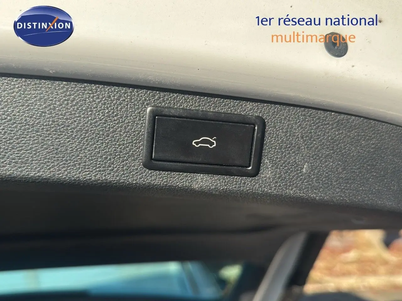 Bouton de déverrouillage électrique du hayon sur un Skoda Kodiaq blanc 2018, vue intérieure du coffre.