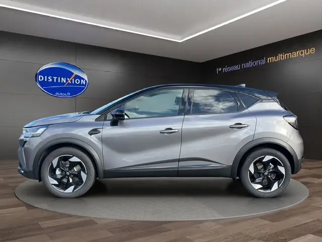 Vue de profil côté gauche du Renault Captur 2025 gris Cassiopée avec toit noir et roue de secours visible en arrière.