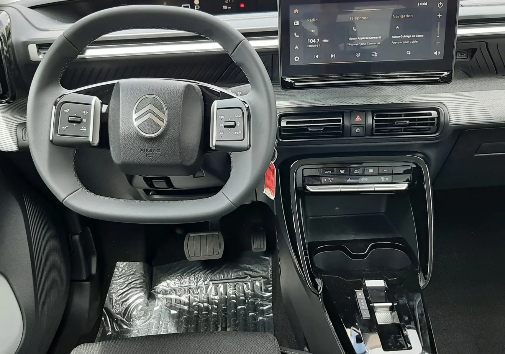 Vue intérieure avant centrée sur le volant Citroën C3 Aircross 2026, avec écran tactile et console noire brillante.