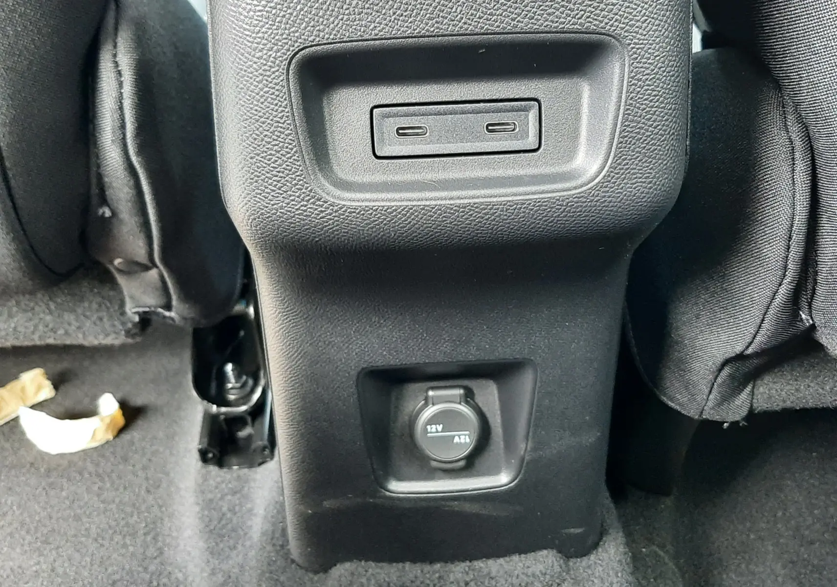 Vue rapprochée de la console arrière noire avec prises USB-C et prise 12V du Citroën C3 Aircross blanc banquise.