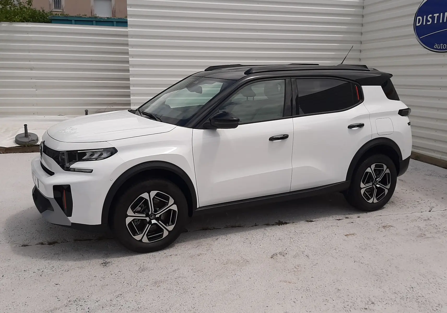 Vue latérale droite d'un Citroën C3 Aircross blanc banquise avec toit noir, roues stylisées et lignes modernes.