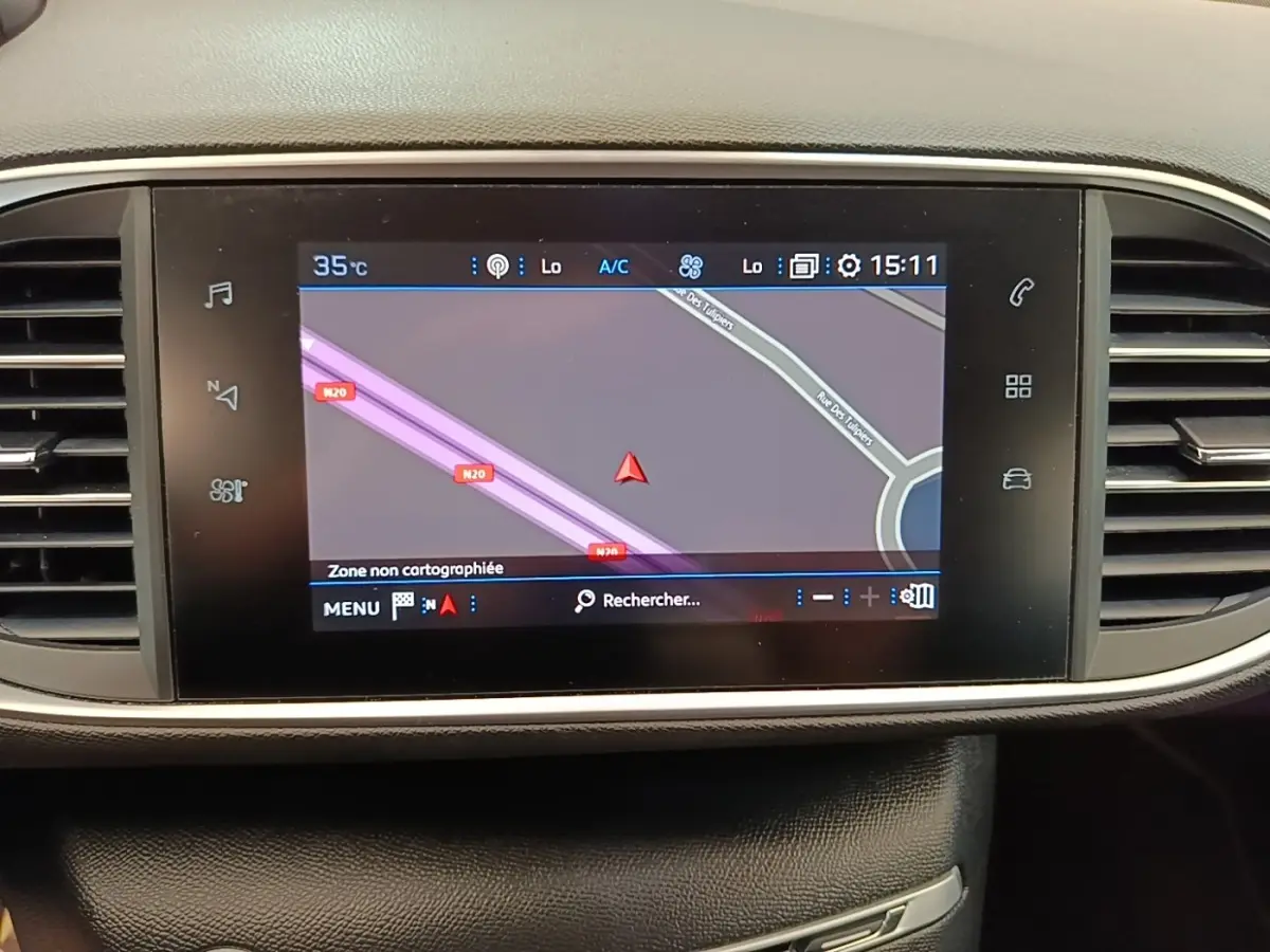 Écran tactile central du tableau de bord de la Peugeot 308 blanc, affichant la navigation GPS en mode carte.