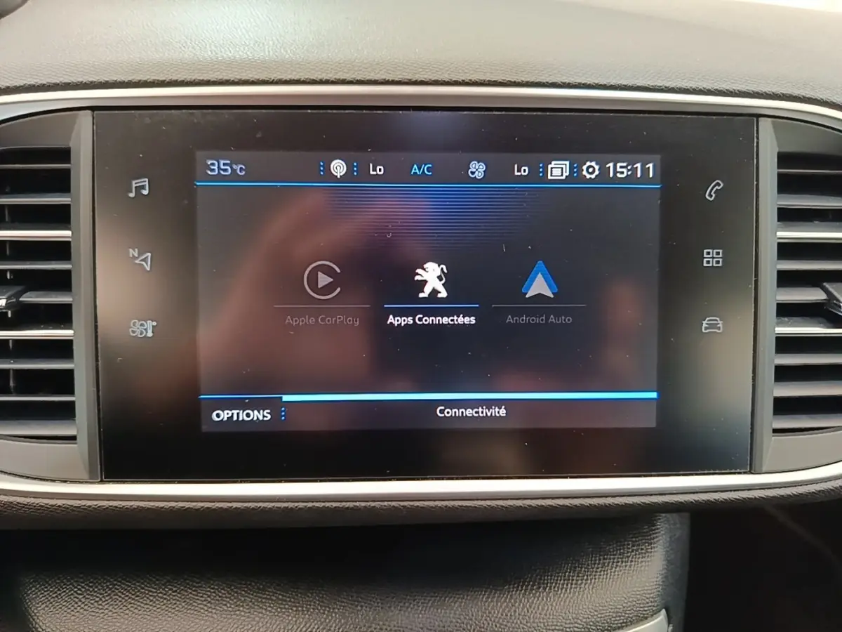 Écran tactile central du tableau de bord de la Peugeot 308 blanc, affichant les options Apple CarPlay et Android Auto.