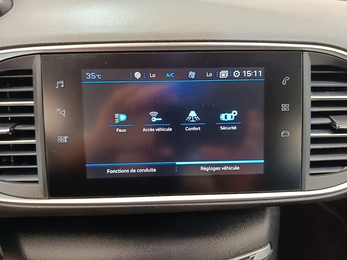 Écran tactile central de la Peugeot 308 blanc, affichant les réglages véhicule et fonctions de conduite.