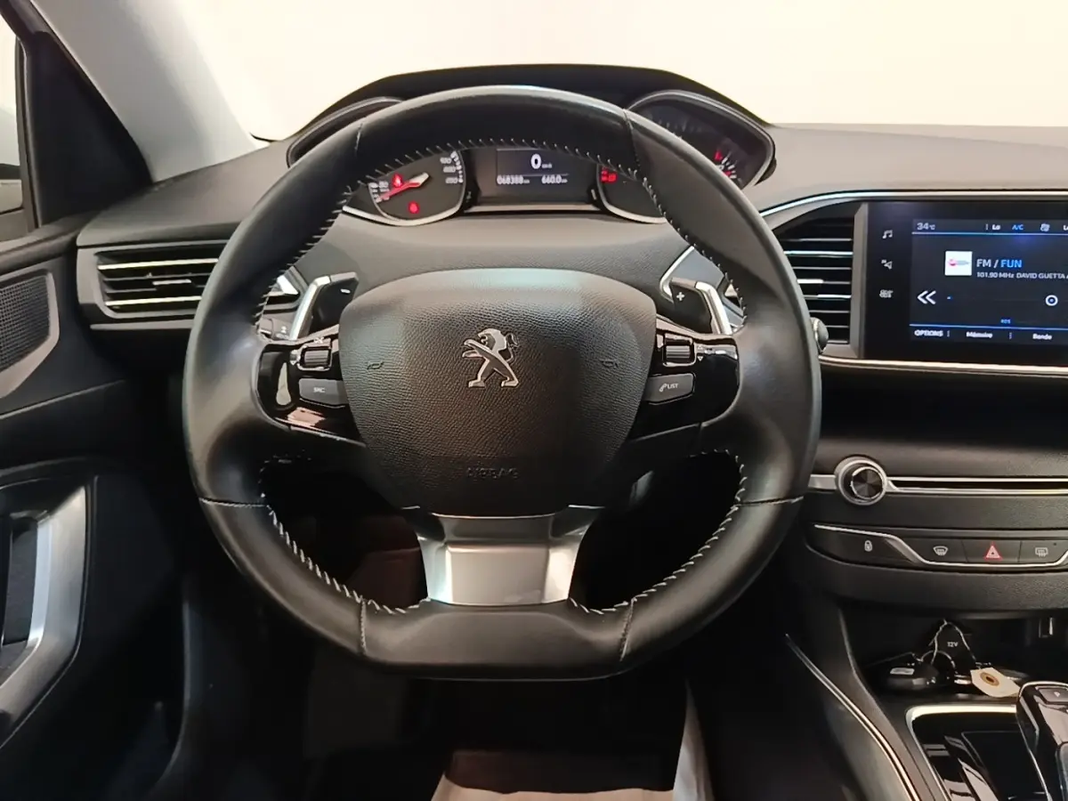 Vue centrée sur le volant cuir noir et le tableau de bord avec écran tactile de la Peugeot 308 2020.