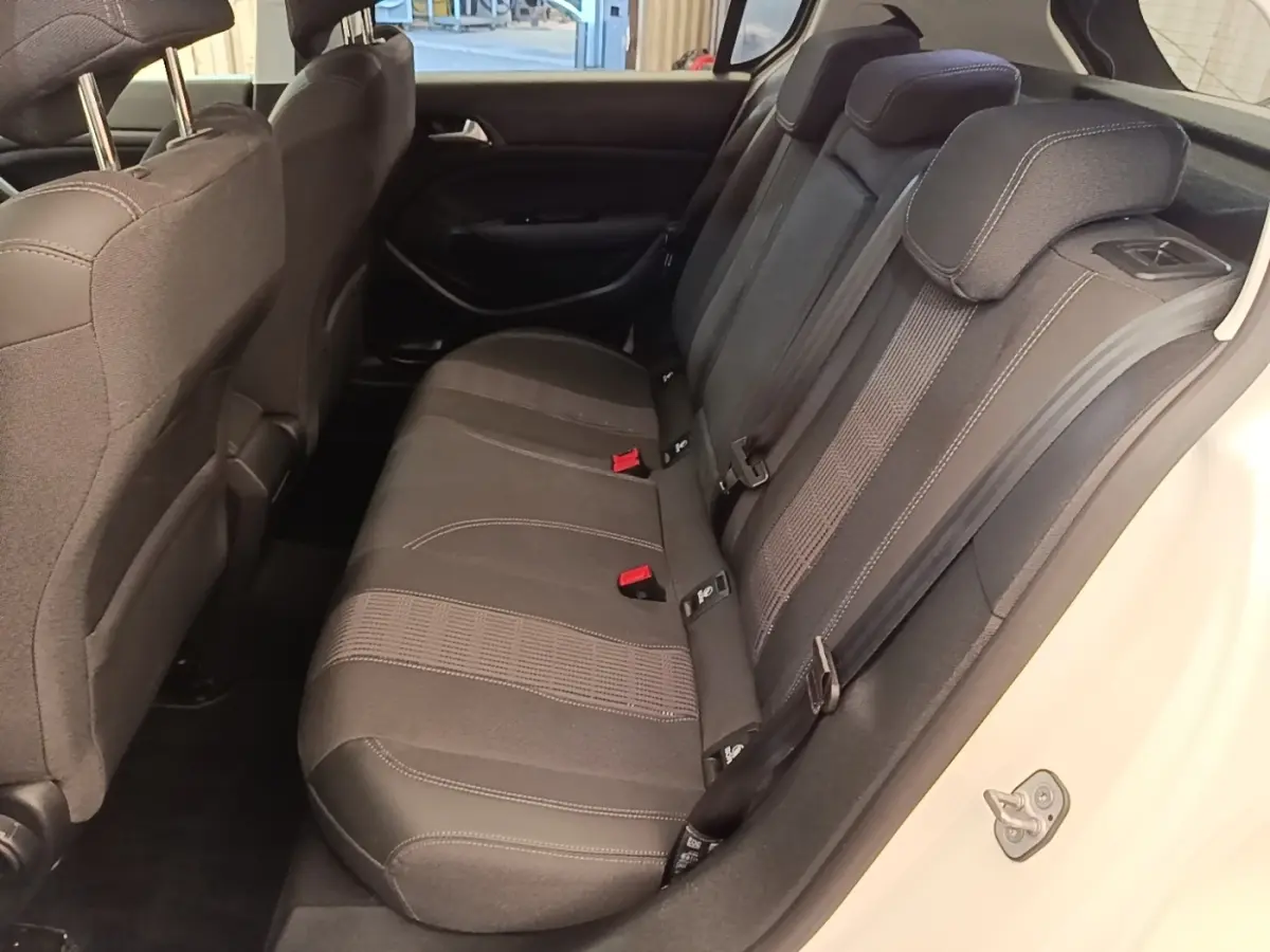 Vue intérieure côté droit de la banquette arrière noire de la Peugeot 308 blanche, avec ceintures et appuie-têtes visibles.