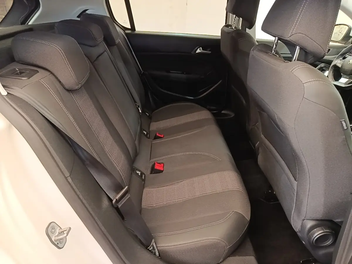 Vue intérieure côté gauche des sièges arrière noirs de la Peugeot 308 BlueHDi 130 Allure blanche de 2020.
