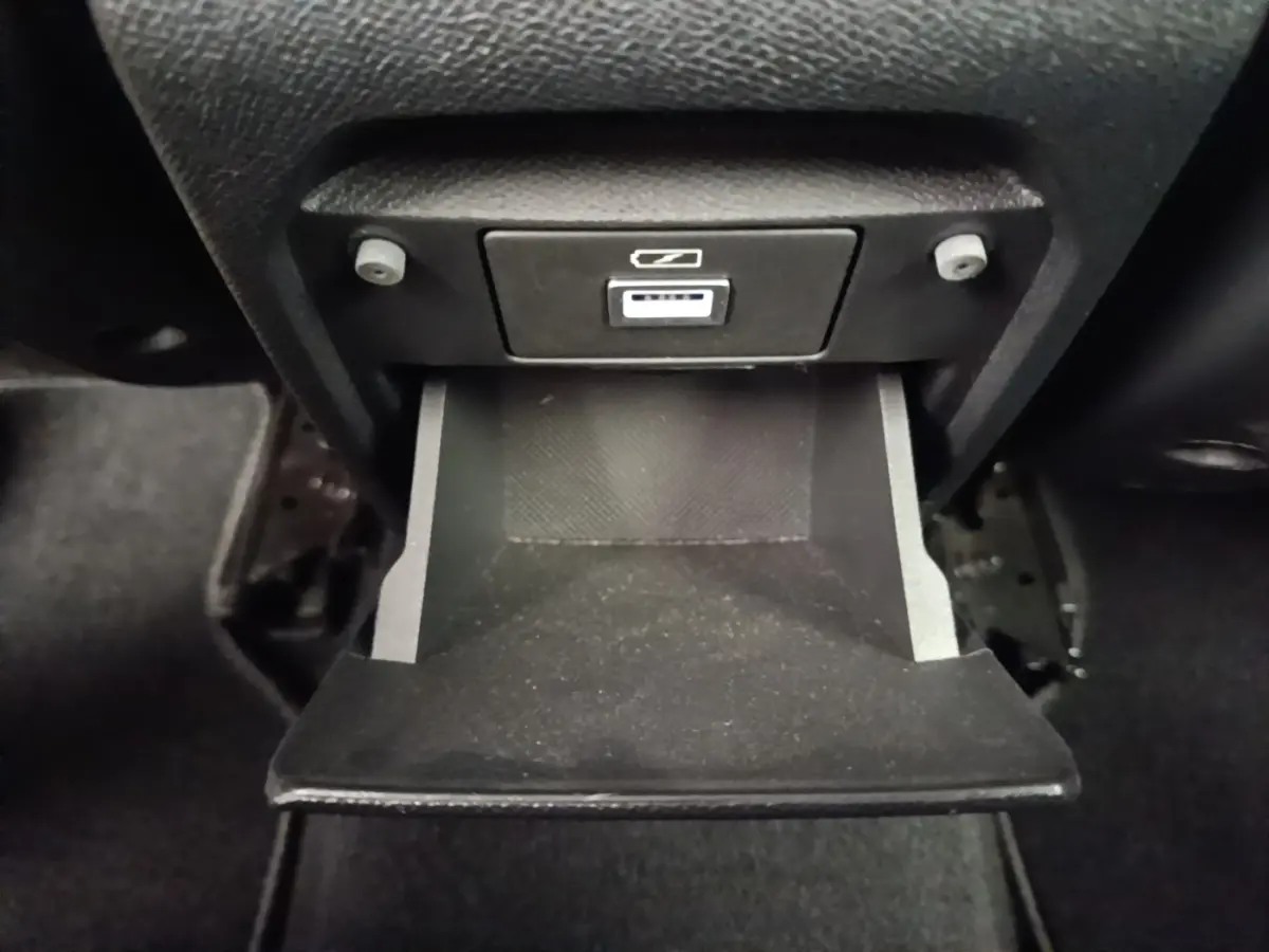 Gros plan sur le rangement réfrigéré ouvert avec prise 12V dans l'habitacle noir de la Peugeot 308 2020.