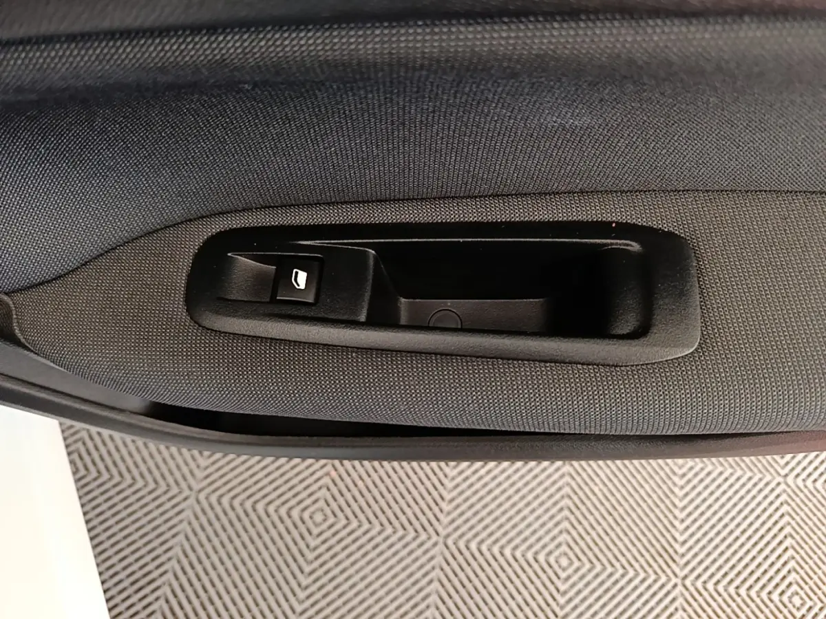 Poignée intérieure de porte arrière droite en tissu noir sur Peugeot 308 BlueHDi 130 EAT8 blanche, vue rapprochée.