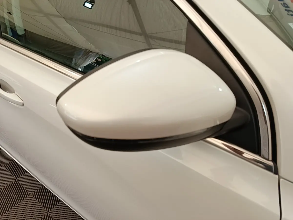 Gros plan sur le rétroviseur côté conducteur blanc de la Peugeot 308 BlueHDi 130 EAT8 S&S Allure 2020.