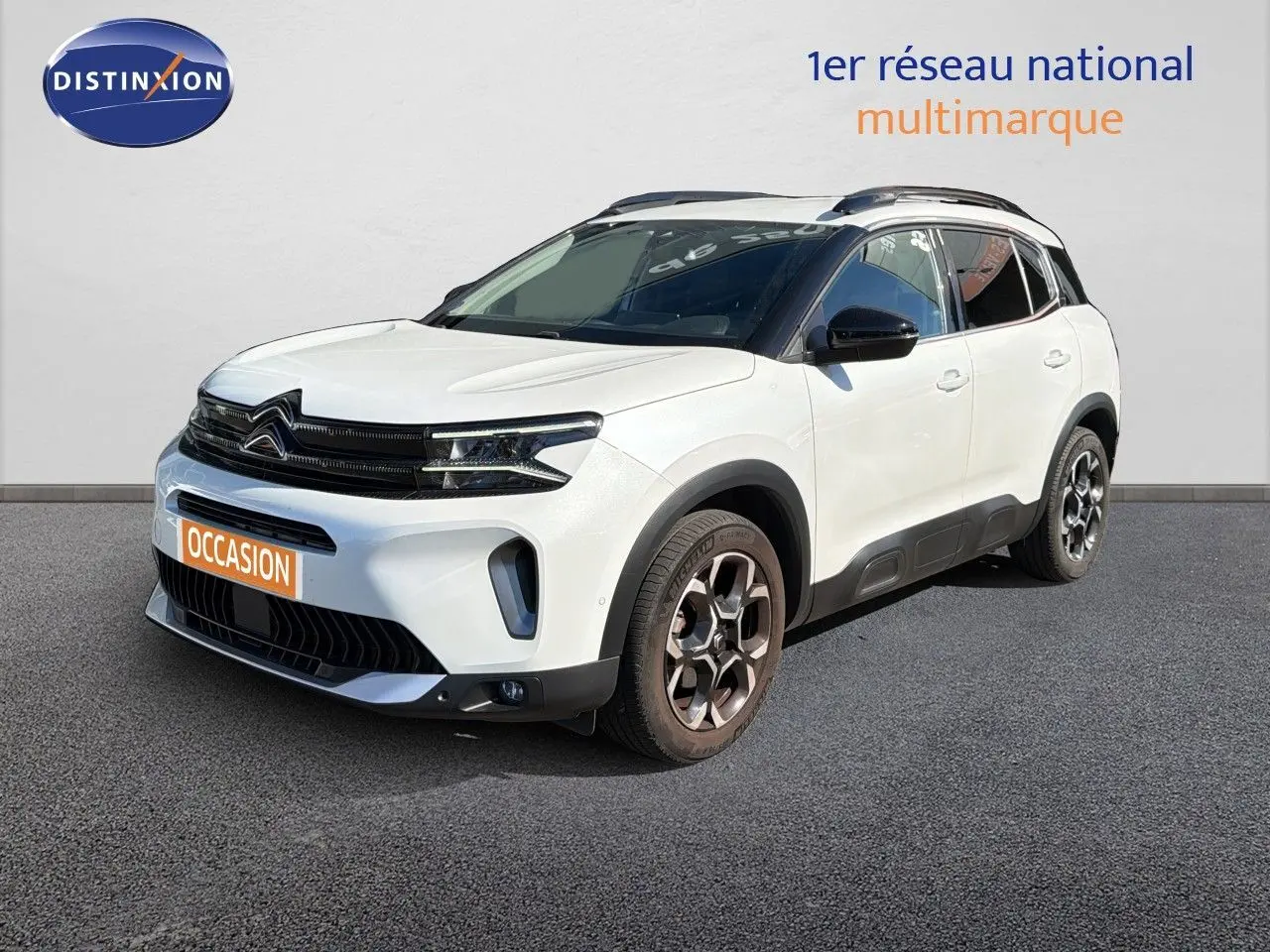 Citroën C5 Aircross blanc nacré métal en 3/4 avant droit, avec toit noir et jantes bi-ton distinctives.