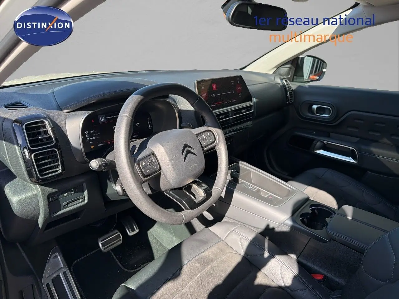 Intérieur de Citroën C5 Aircross 2023 vu côté conducteur, tableau de bord moderne avec écran tactile et volant multifonction.