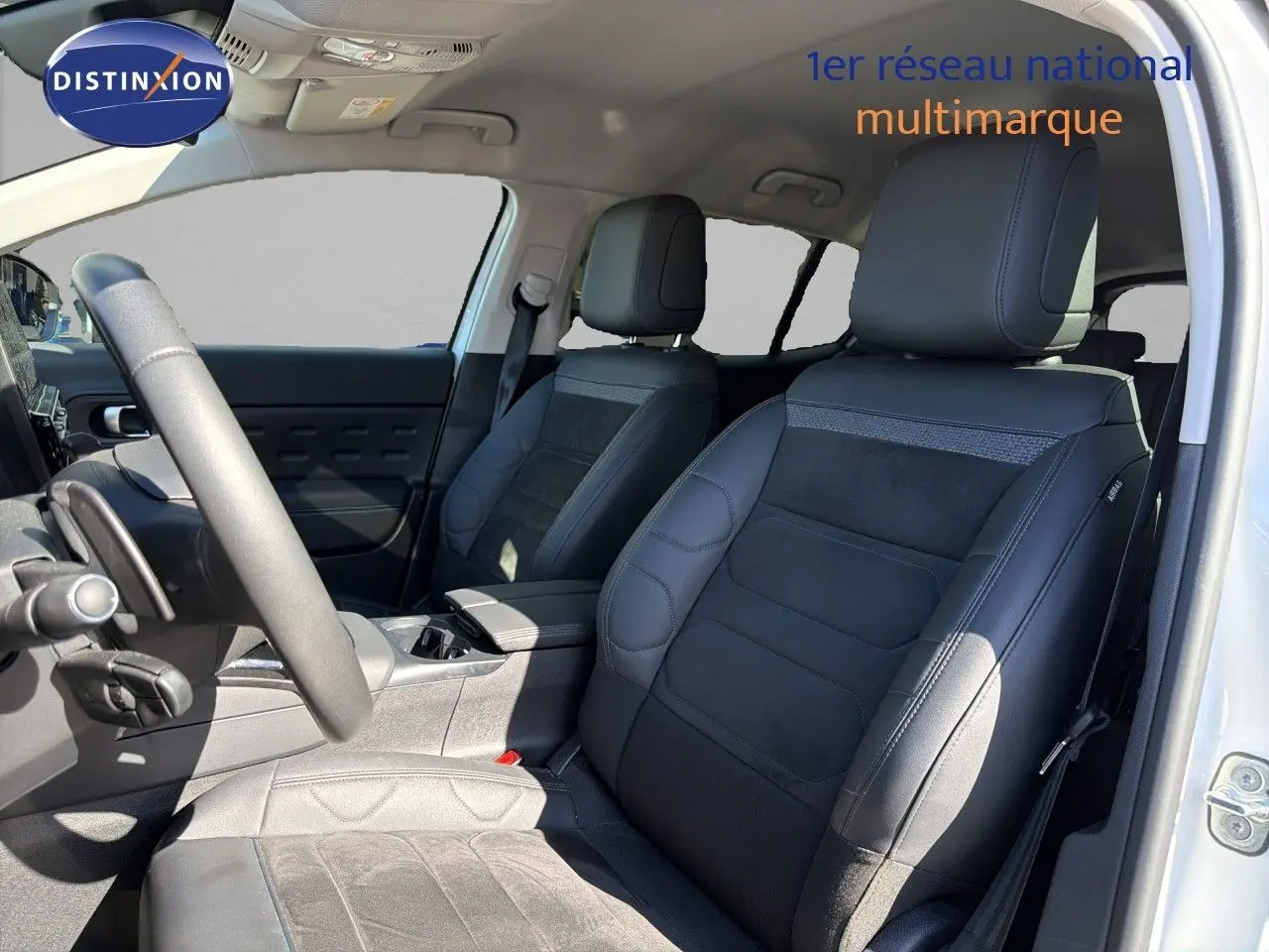 Vue intérieure côté conducteur du Citroën C5 Aircross blanc nacré, mettant en valeur les sièges noirs en cuir et alcantara.