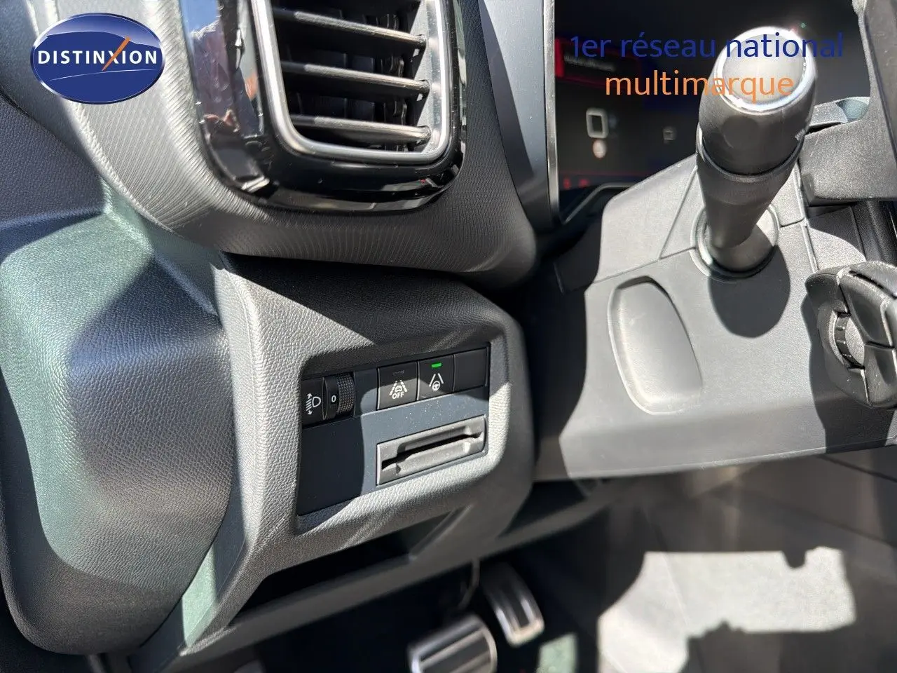 Détail intérieur montrant les commandes d'assistance et la sortie d'aération côté gauche du tableau de bord d'un Citroën C5 Aircross blanc nacré.