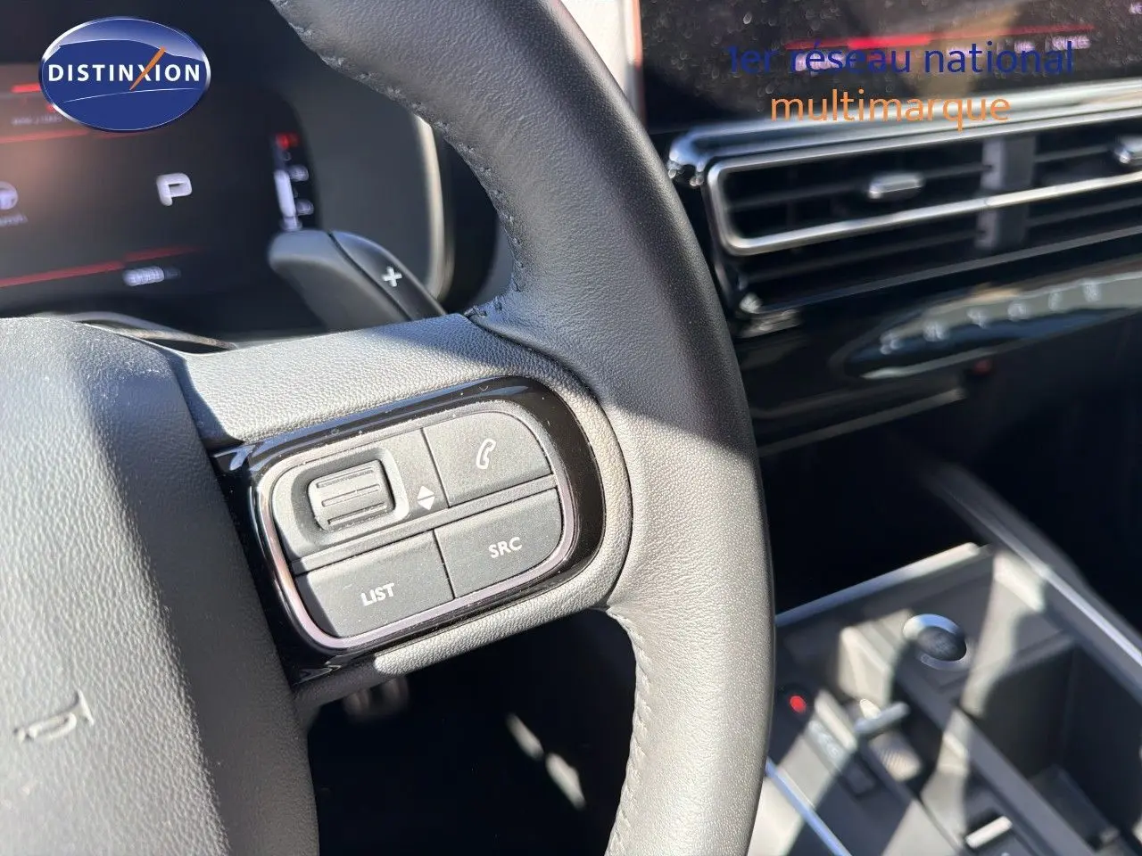 Gros plan sur le volant noir de la Citroën C5 Aircross 2023, montrant les commandes audio et téléphone côté gauche.
