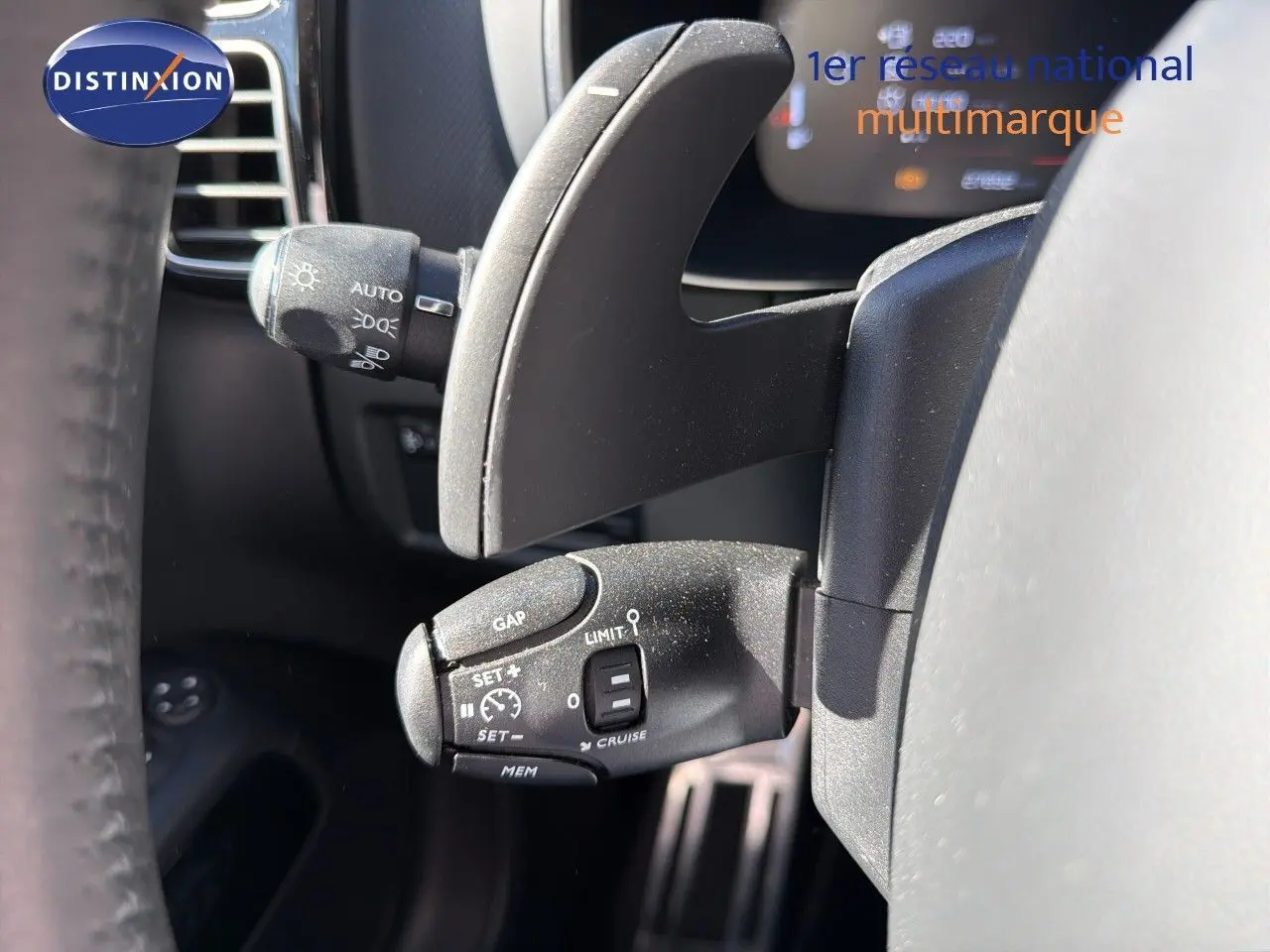 Gros plan sur le commodo de régulateur de vitesse du Citroën C5 Aircross blanc nacré, intérieur côté gauche du volant.