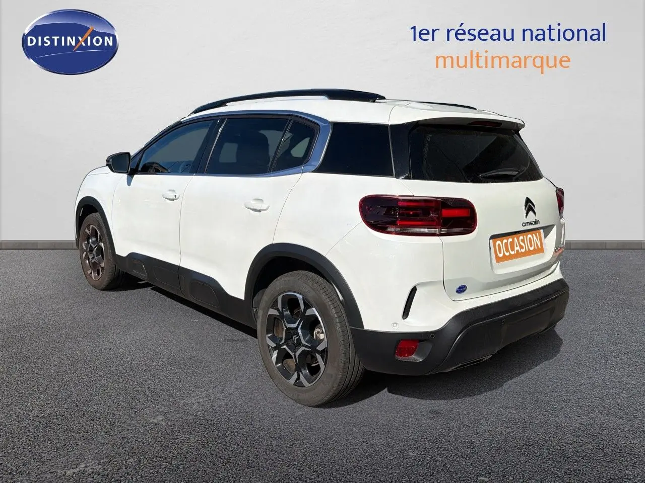 Vue 3/4 arrière droite d'un Citroën C5 Aircross blanc nacré avec toit noir et jantes alliage foncé.