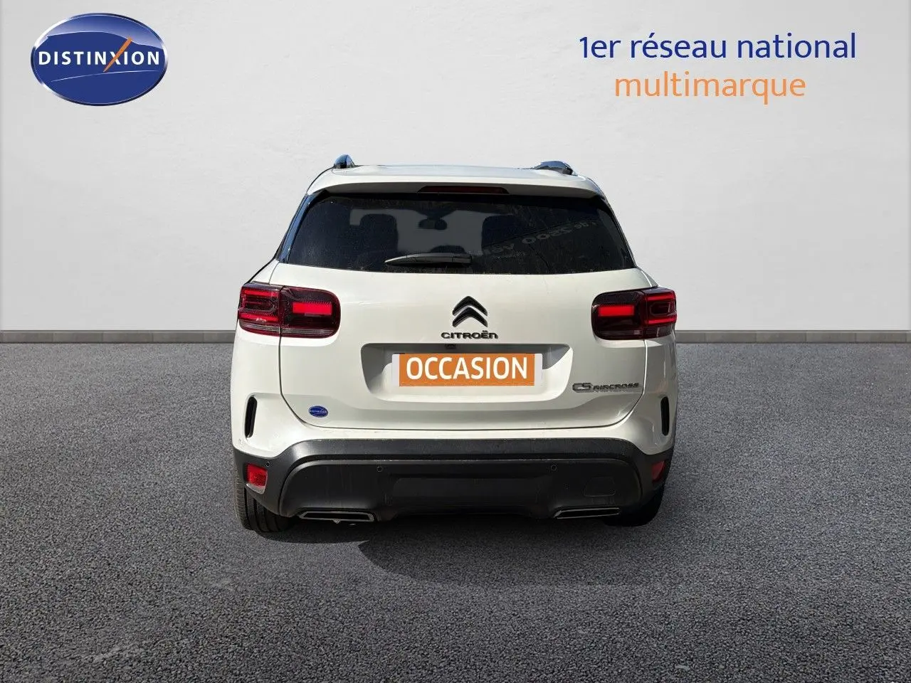 Vue arrière d'un Citroën C5 Aircross blanc nacré métal avec feux rouges et logo centré sur fond neutre.