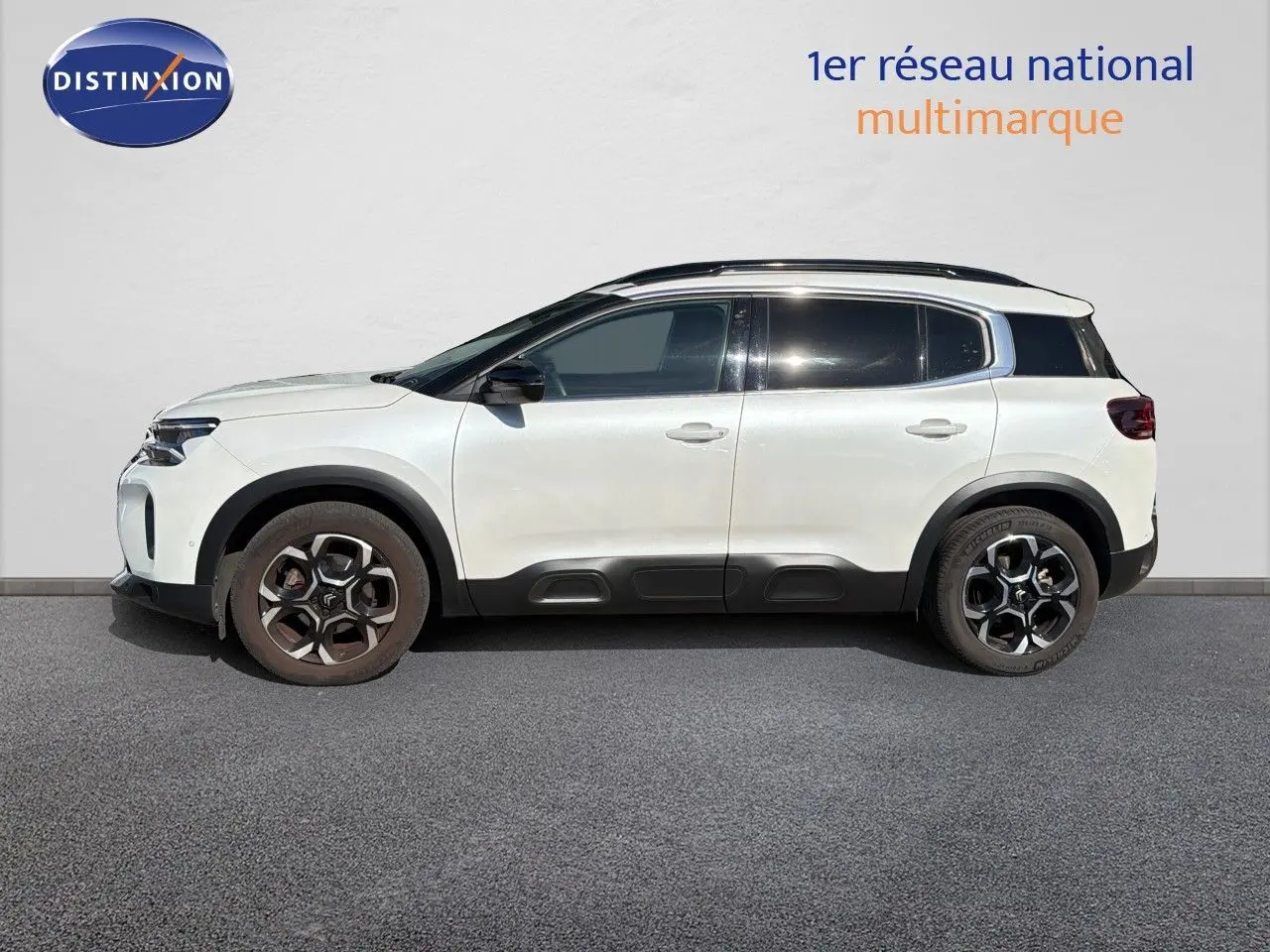 Profil droit d'un Citroën C5 Aircross blanc nacré métal 2023 avec toit noir et jantes alliage bicolores.