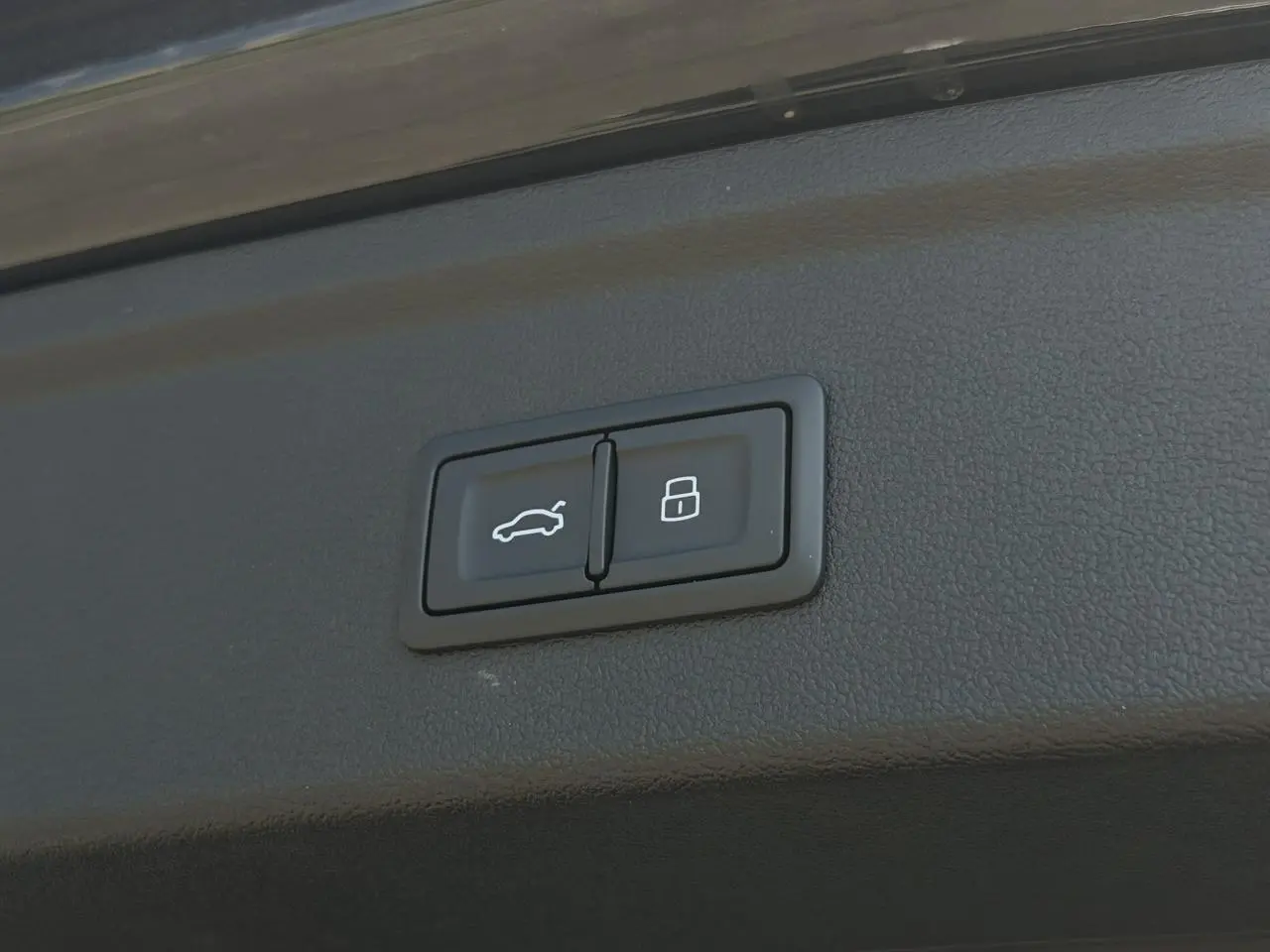 Gros plan sur les boutons d'ouverture et de verrouillage du hayon électrique de l'Audi A3 Sportback noir Mythe.
