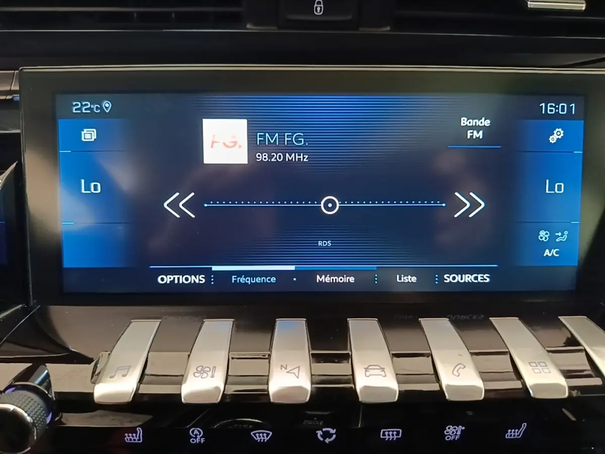 Écran tactile central de la Peugeot 508 gris foncé affichant la radio FM et commandes piano en façade.