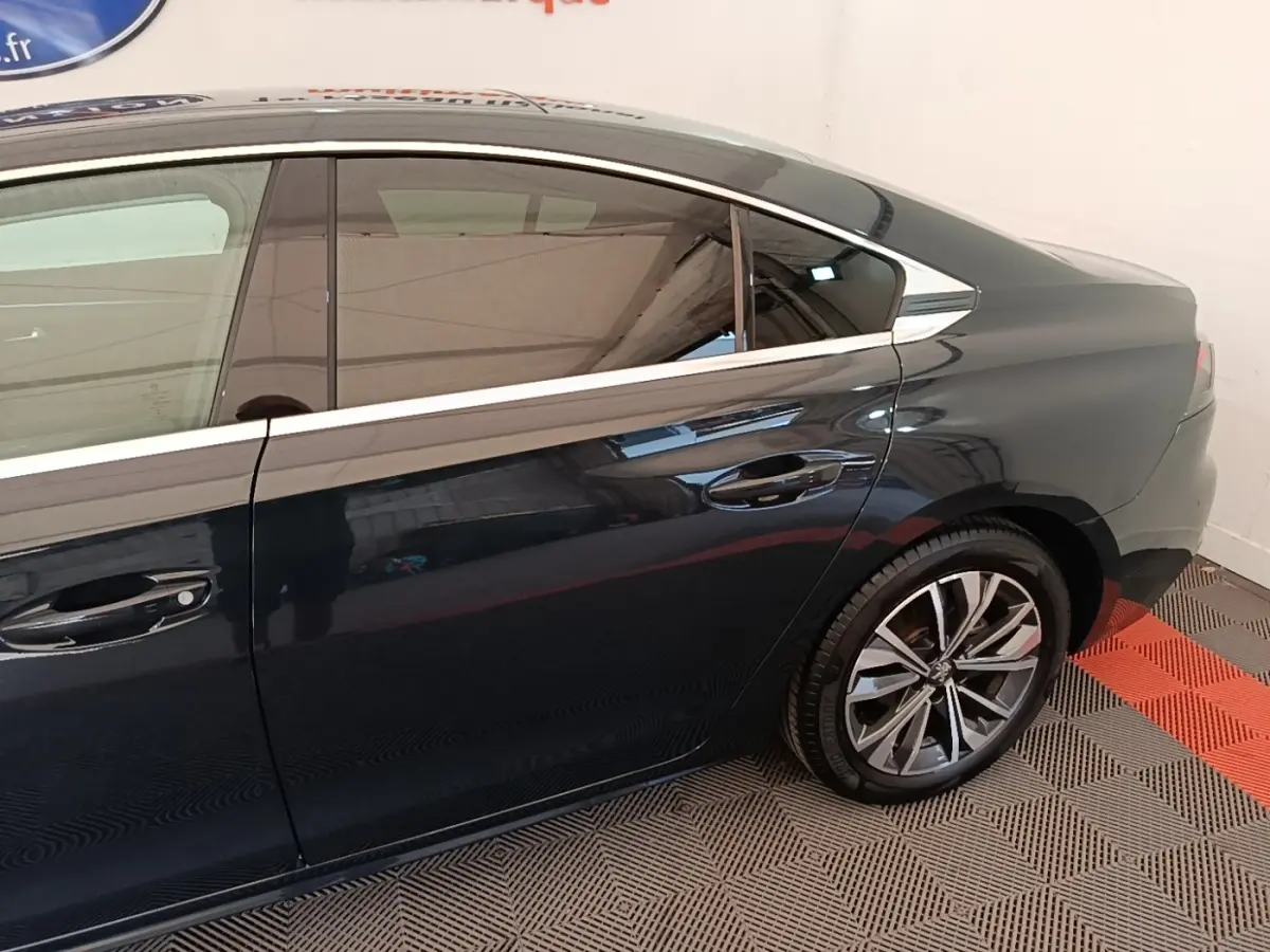 Vue latérale côté droit d'une Peugeot 508 gris foncé avec jantes alliage et vitres teintées.