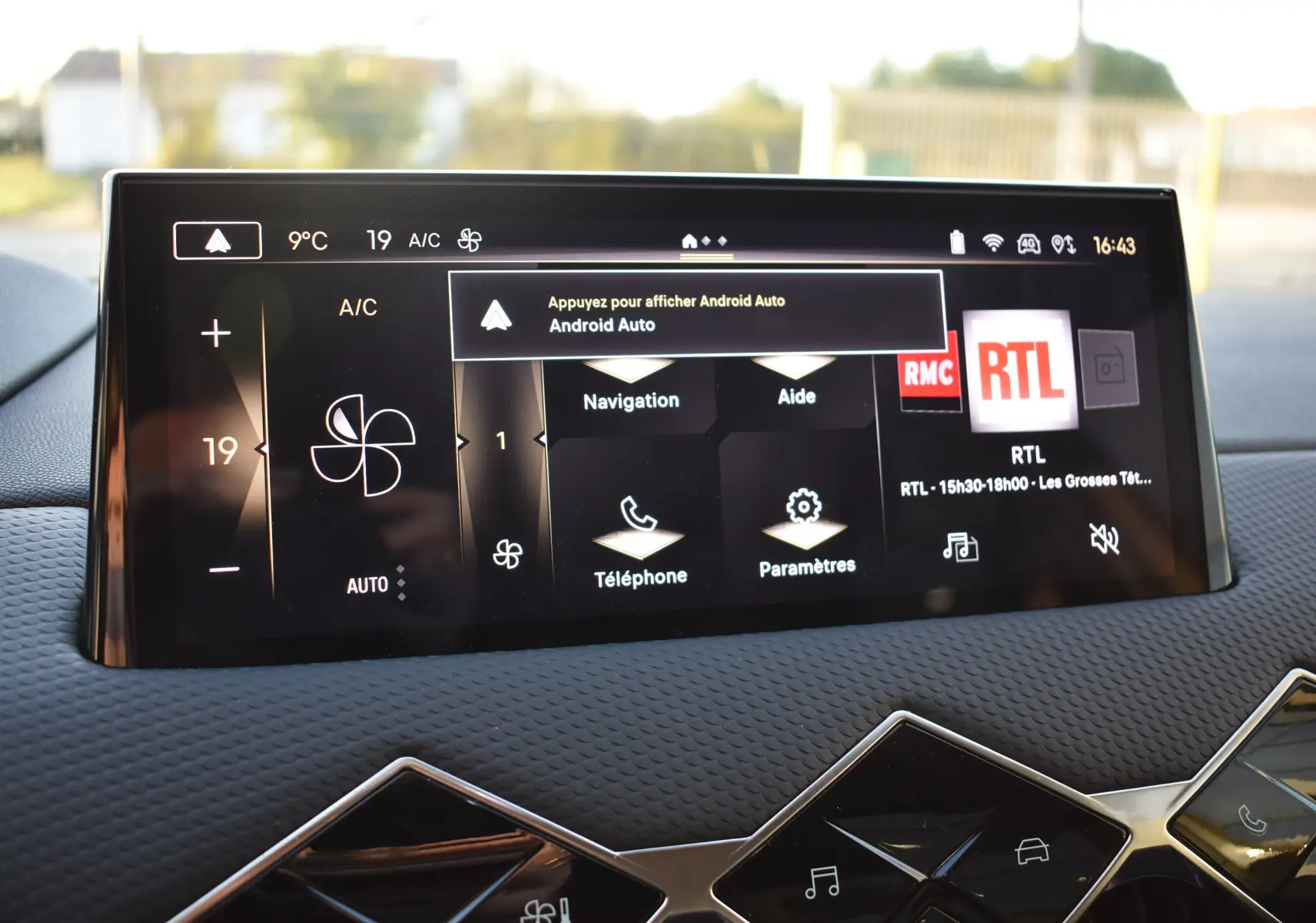 Écran tactile central du DS3 Crossback 2024 affichant la climatisation et les options Android Auto, avec tableau de bord texturé noir.