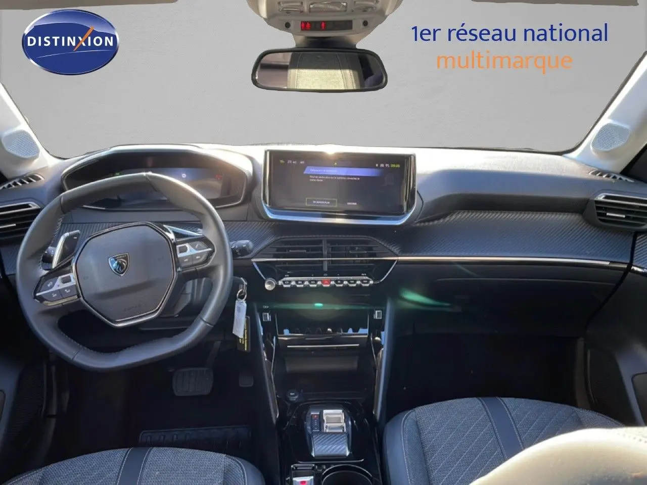 Vue intérieure avant de la Peugeot 208 noire 1.2 Hybrid 110ch avec tableau de bord moderne et écran tactile central.
