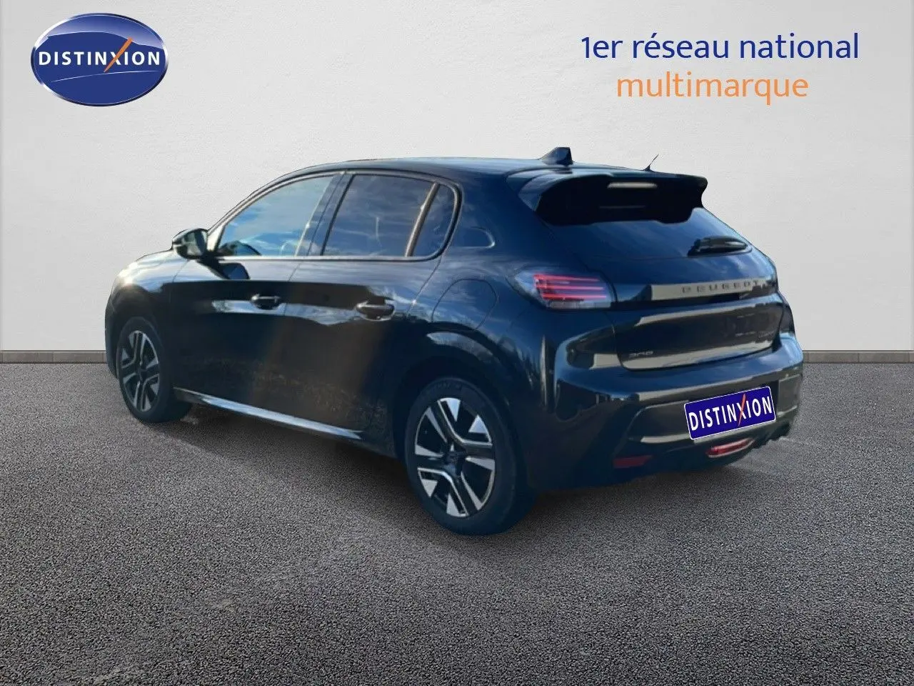 Vue 3/4 arrière droite d'une Peugeot 208 noire 2025 hybride avec jantes distinctives et toit spoiler.